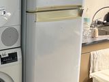 deux lave-linge et un sèche-linge empilés les uns sur les autres
