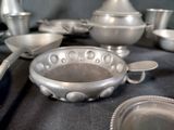 a table with a lot of silver dishes and pans on it