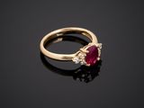 an oval ruby and diamond ring on a black surface