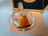 a picture of a woman holding a bottle of perfume in front of a mirror