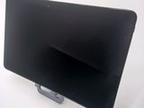 a black tablet computer sitting on a stand on a white surface