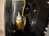 a bottle of mustard in a metal container on the floor