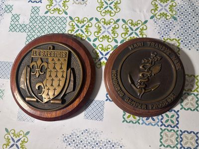 deux médailles posées sur une table décorée d'un motif
