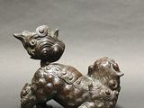 a bronze statue of a dog on its hind legs