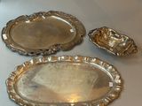 three silver trays sitting on a table next to each other