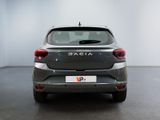 the back end of a silver car in a white room