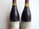 two bottles of wine sitting next to each other on a table