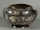 a silver bowl with a bird and flowers design on it
