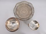 three pieces of silverware are sitting on a white surface