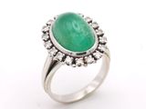 a close up of a ring with a green stone surrounded by diamonds