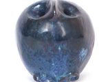 a blue vase that is sitting on a white surface