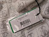 a tag on a white dress with silver sequins on it