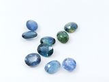 a group of blue and green gems sitting on top of a white surface