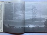 an open book with a picture of a field in the background