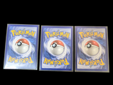 three pokemon cards are sitting on top of each other on a table