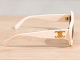 white sunglasses with a gold logo on the side on a wooden table