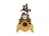 une horloge en or surmontée d'un cheval et d'un cavalier