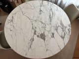 a marble table with chairs around it in front of a window