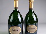 two bottles of champagne sitting next to each other on a table