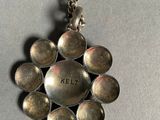 a silver necklace with a flower design on it