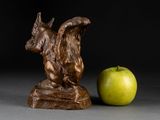 a statue of a dog and an apple on a table
