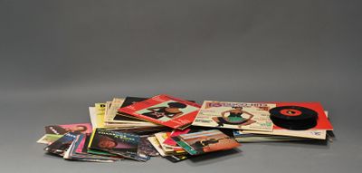 une pile de livres posée sur une table, à côté d'un disque vinyle