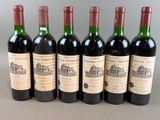 six bottles of wine are lined up in a row on a table