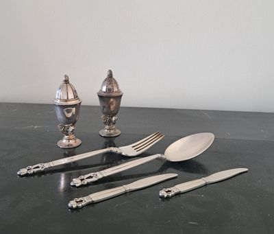 beaucoup de couverts sur une table où se trouvent déjà des couverts