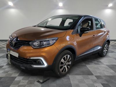 La voiture orange est garée sur un sol à damier dans le garage.