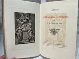 someone is holding a book with a picture of a statue in it