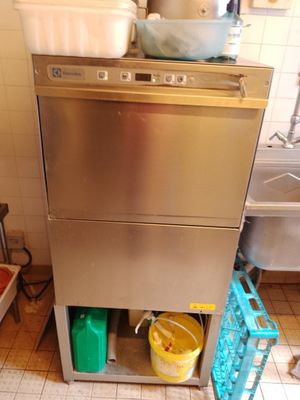 un lave-vaisselle dans une cuisine où il y a beaucoup de vaisselle sur le plan de travail