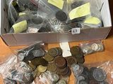 une boîte remplie de pièces posée sur une table, à côté d'une pile d'autres pièces