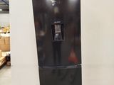 a black refrigerator sitting on a wooden pallet in a warehouse