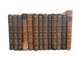 several old books are lined up in a row on a white surface