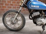 a blue motorcycle parked in front of a brick wall