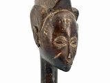 wooden statue of a man with a hat on his head and hands on his chest