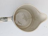 a white cup with a handle on a white table