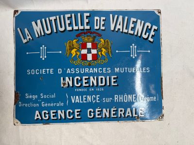 panneau accroché au mur d'un immeuble et orné d'un blason