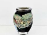 a black vase with a painting on it sitting on a table