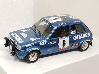a toy car that is on display on a white shelf