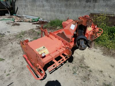 a small orange machine that is sitting in the dirt