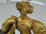 a gold statue of a woman sitting on a black horse