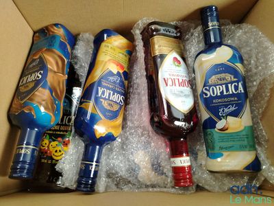des bouteilles de différents types d'alcool dans une boîte posée sur une table