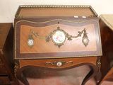 a small desk with a clock on top of it