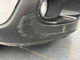 a close up of a car ' s front bumper with a denting on it