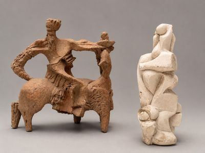 two sculptures of a man and a woman on a horse