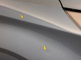 a yellow arrow on the side of a silver car
