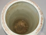 a white cup with a brown design on it