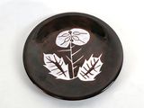 a brown and white plate with a flower on it