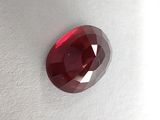 a close up of a red diamond on a white surface